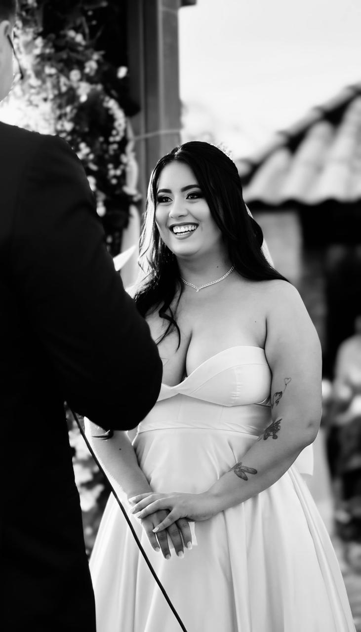 Noiva sorrindo no altar, em preto e branco